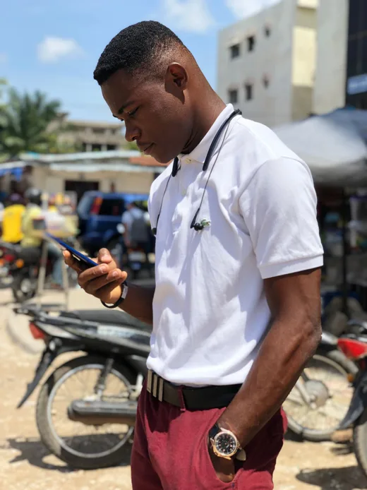 A man checking a payment on his phone at a street market