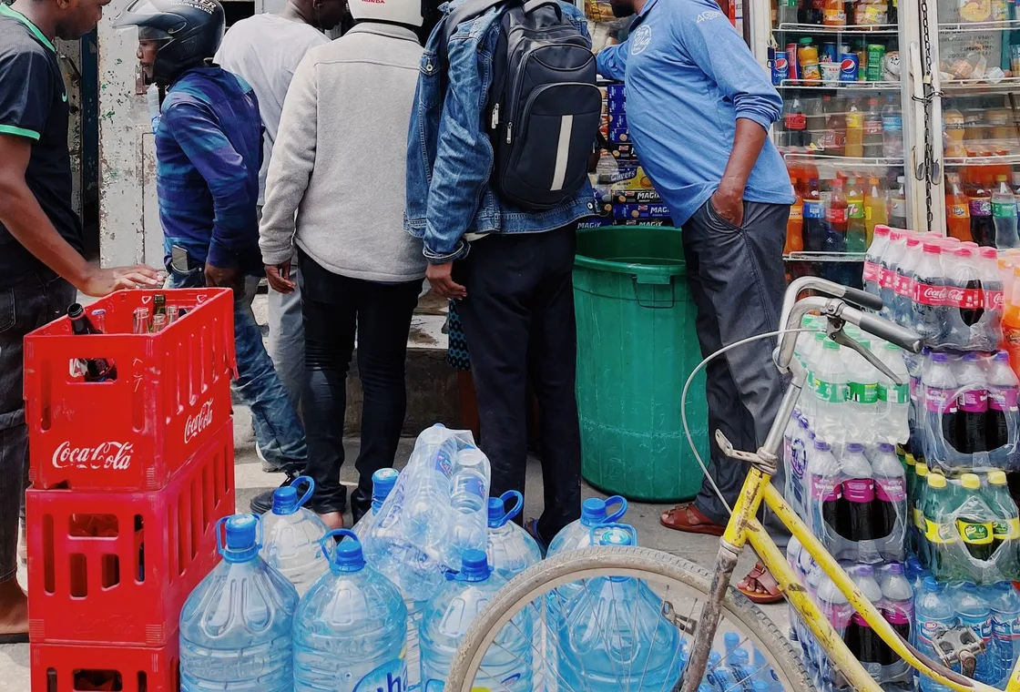 Customers at the counter of a small shop selling airtime and bundles